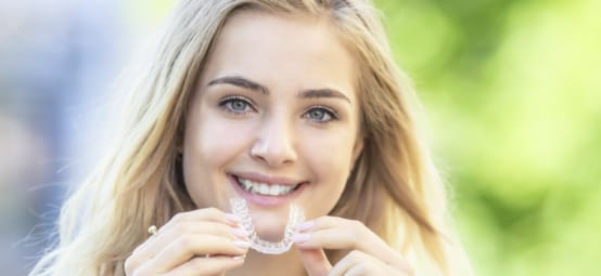 A Teenager Demonstrating Invisalign Aligners